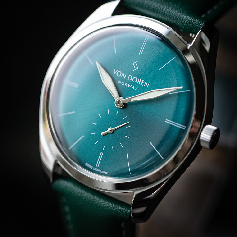 Von Doren klokke Runde Opal. Opalfarget skive med hvite indekser og grønn skinnreim.