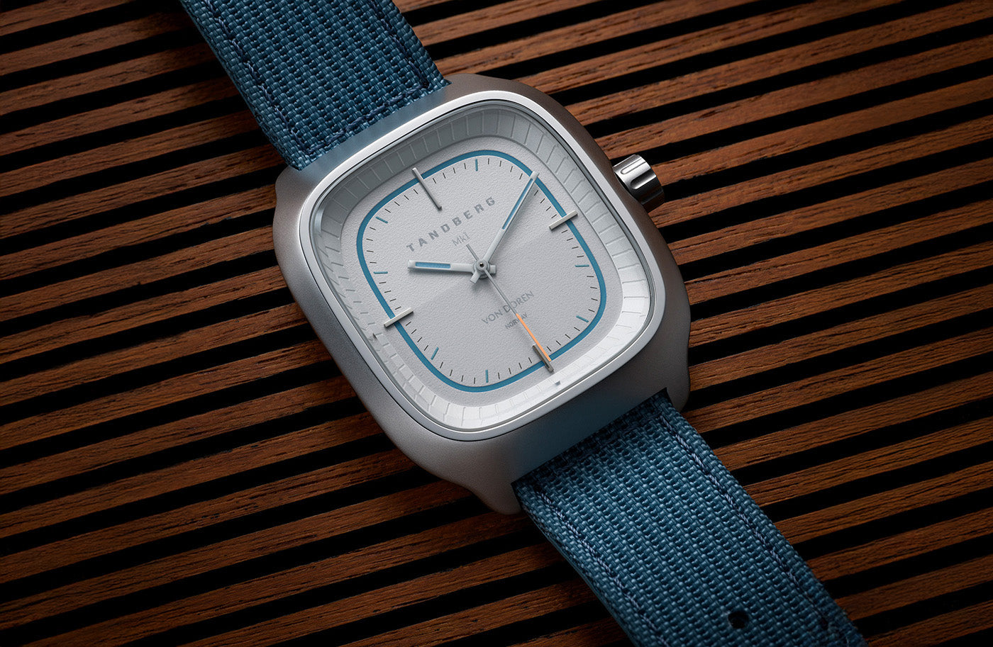 Von Doren Tandberg watch with blue strap on wooden slatted surface.