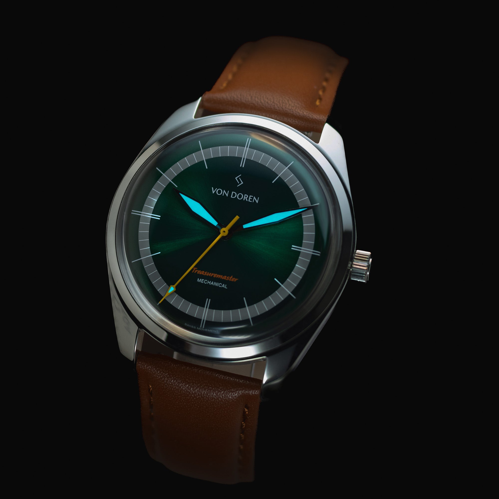 Klokke fra Von Doren. Den har grønn skive og brun skinnreim. Visere som lyser i mørket.