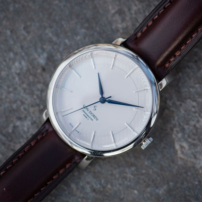 Von Doren klokke med hvit skive og mørk brun skinnreim.