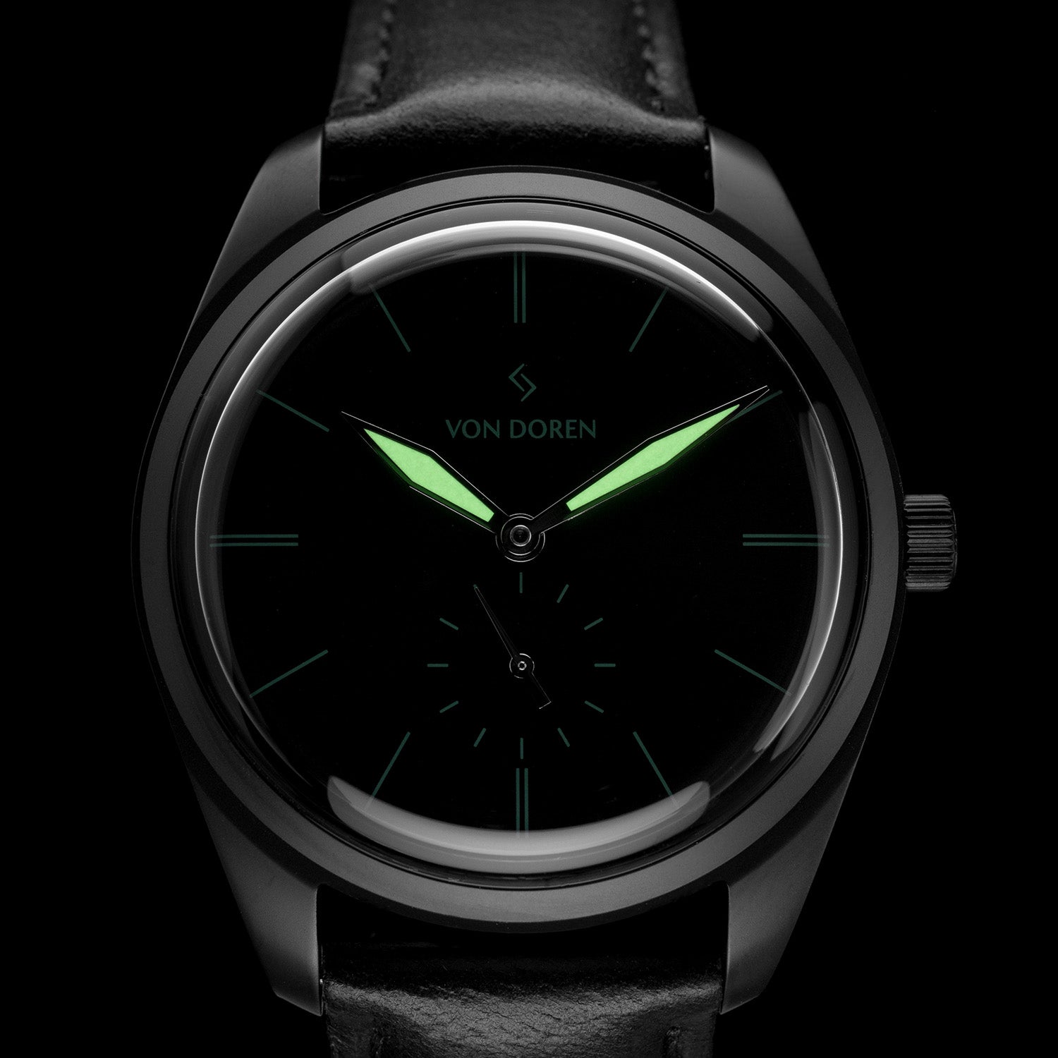 Klokke som har sort kasse, skive og reim, med selvlysende visere.